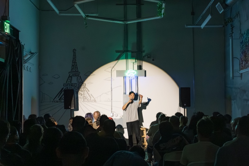 Comedian performing on stage under spotlight at Spaced Out Comedy San Jose